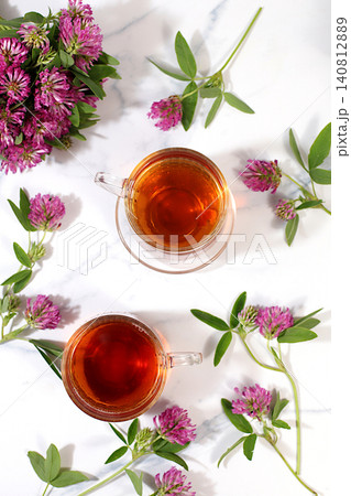 Red clover infusion in glasses with a bouquet of flowers, medicinal herbal tea, alternative folk medicine concept, "green pharmacy" advertisement, a collection of beneficial herbs for folk medicine, Red clover infusion in glasses with a bouquet of flowers, medicinal herbal tea, alternative folk medicine concept, "green pharmacy" advertisement, a collection of beneficial herbs for folk medicine, 140812889