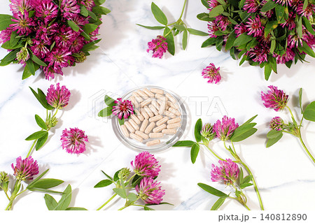 Red clover powder in capsules with a bouquet of flowers, a medicinal herbal composition, an alternative folk medicine concept, an advertisement for a green pharmacy, a collection of useful herbs Red clover powder in capsules with a bouquet of flowers, a medicinal herbal composition, an alternative folk medicine concept, an advertisement for a green pharmacy, a collection of useful herbs 140812890