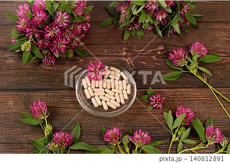 Red clover powder in capsules with a bouquet of flowers, a medicinal herbal composition, an alternative folk medicine concept, an advertisement for a green pharmacy, Red clover powder in capsules with a bouquet of flowers, a medicinal herbal composition, an alternative folk medicine concept, an advertisement for a green pharmacy, 140812891