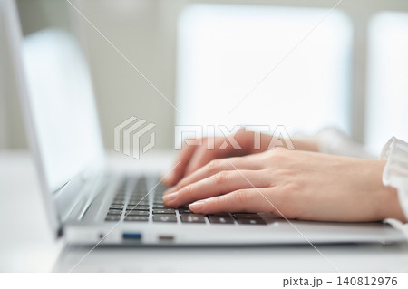 ノートパソコンで作業をする若い女性の手元 140812976