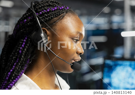 Engineer wears a headset in a server room, using artificial intelligence troubleshooting to assist users. Engineer wears a headset in a server room, using artificial intelligence troubleshooting to assist users. 140813140