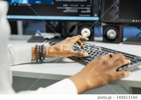 Computer scientist works with desktop computer in a data center to support data processing, analytics, and storage infrastructure. 140813160