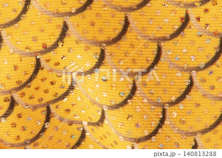 Yellow fabric in scales gray macro background with fold. Yellow fabric in scales gray macro background with fold. 140813288
