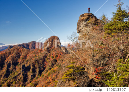 丁頭ノ頭から見る岩峰に立つ登山者と紅葉の山並み 丁頭ノ頭から見る岩峰に立つ登山者と紅葉の山並み 140813597