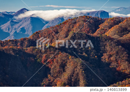 裏妙義・丁頭ノ頭付近から見る紅葉の山並みと八ヶ岳遠望 140813899