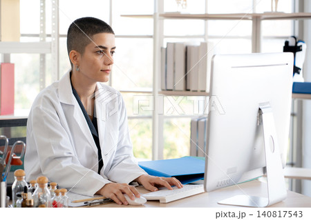 professional woman doctor sitting working with computer looking at monitor. professional woman doctor sitting working with computer looking at monitor. 140817543