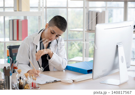 Caucasian woman doctor sitting and working with computer monitor and record document. Caucasian woman doctor sitting and working with computer monitor and record document. 140817567