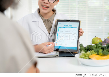 Asian nutritionist showing AI meal plan on tablet to senior patient, digital health technology. Asian nutritionist showing AI meal plan on tablet to senior patient, digital health technology. 140817570