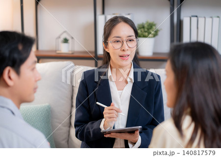 Asian couple sitting on sofa consulting with psychologist for marriage therapy. Asian couple sitting on sofa consulting with psychologist for marriage therapy. 140817579