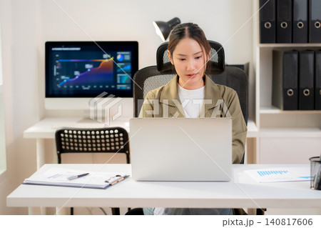 Asian businesswoman sitting working on laptop at office. Asian businesswoman sitting working on laptop at office. 140817606