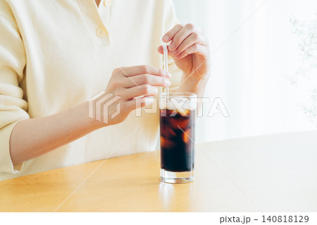 家でアイスコーヒーを飲む若い女性の手元 家でアイスコーヒーを飲む若い女性の手元 140818129
