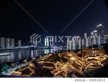 the glowing, wave-like roofs of the historic Huguang Guild Hall cast a radiant silhouette in the foreground, creating a striking contrast with the towering modern skyscrapers across the river. The the glowing, wave-like roofs of the historic Huguang Guild Hall cast a radiant silhouette in the foreground, creating a striking contrast with the towering modern skyscrapers across the river. The 140818211