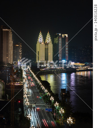 The twin, golden-crowned spires of the Sheraton Chongqing Hotel rise majestically over Nan'an District, their ornate, glowing architecture standing out against the dark night sky. The iconic towers The twin, golden-crowned spires of the Sheraton Chongqing Hotel rise majestically over Nan'an District, their ornate, glowing architecture standing out against the dark night sky. The iconic towers 140818228
