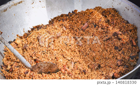 Chef serving traditional indian biryani rice with meat in large pot 140818330