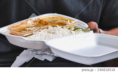 Person holding Indian street food takeaway with basmati rice and curry during India Day in Moscow 140818510