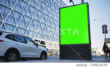 A blank vertical green screen billboard on a city street with a modern building and traffic A blank vertical green screen billboard on a city street with a modern building and traffic 140818539