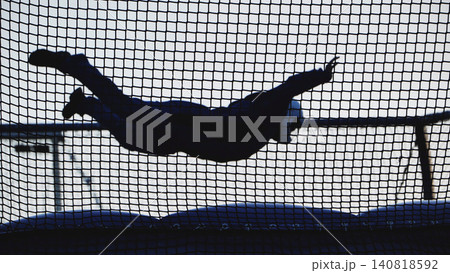 Skydiving simulator silhouette flying in a vertical wind tunnel during indoor training Skydiving simulator silhouette flying in a vertical wind tunnel during indoor training 140818592