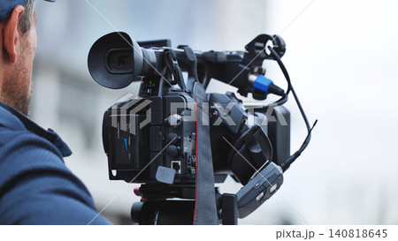 Cameraman recording live broadcast action for television news or film production Cameraman recording live broadcast action for television news or film production 140818645
