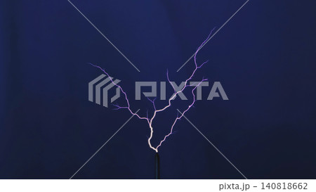 Tesla coil generating high voltage electrical discharge with branching purple sparks Tesla coil generating high voltage electrical discharge with branching purple sparks 140818662