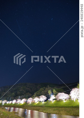 満天の星空の下にライトアップされた美しい夜桜並木と川面のリフレクション 満天の星空の下にライトアップされた美しい夜桜並木と川面のリフレクション 140819448