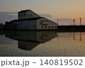夕暮れの水田に美しく映り込むJA金沢市西部ライスセンターの田園風景 140819502