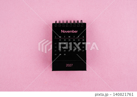 Black calendar for November 2027 year on pink color background. 140821761