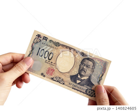 両手で千円札を持つ女性の手元 両手で千円札を持つ女性の手元 140824605
