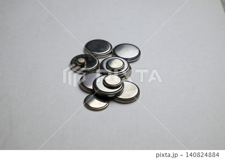 A set of shiny silver metal round batteries of various sizes neatly laid out on a surface A set of shiny silver metal round batteries of various sizes neatly laid out on a surface 140824884