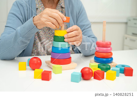Asian elderly woman playing enhancing skill board game. Asian elderly woman playing enhancing skill board game. 140828251