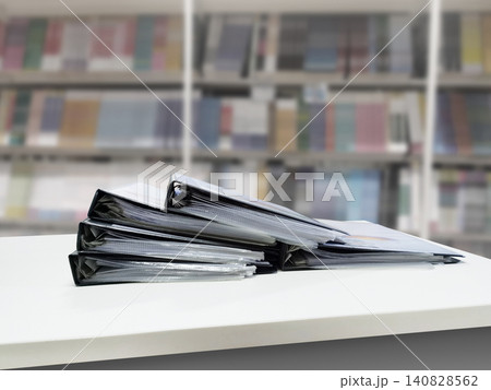 Several document files are placed on a white desk. The background of the documents is blurred. Several document files are placed on a white desk. The background of the documents is blurred. 140828562