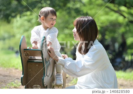 公園でスプリング遊具を楽しむ娘と母親 公園でスプリング遊具を楽しむ娘と母親 140828580