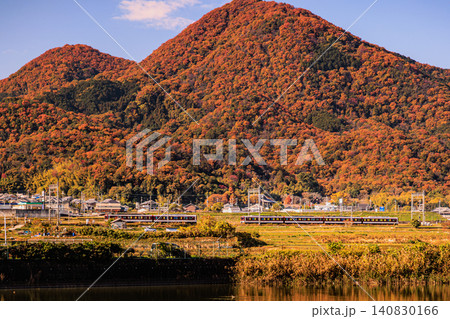 秋の里山風景をバックに走る近鉄の普通電車と二上山の景観 秋の里山風景をバックに走る近鉄の普通電車と二上山の景観 140830166