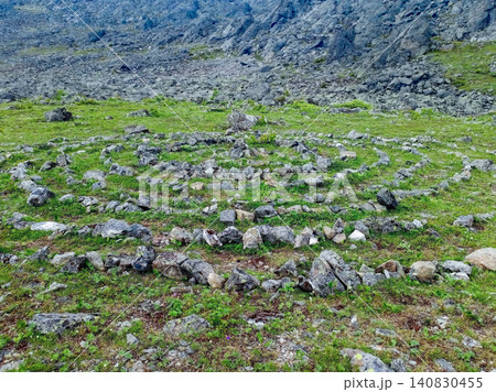 Stone labyrinth on the alpine meadow with green grass among rocks Stone labyrinth on the alpine meadow with green grass among rocks 140830455