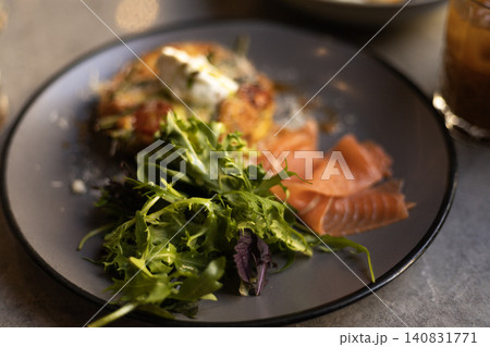 Salmon breakfast platter with green salad served on a dark ceramic plate 140831771