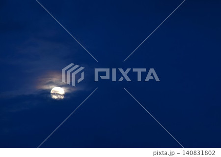 full moon floating and covering by dark cloud on blue sky in twilight background full moon floating and covering by dark cloud on blue sky in twilight background 140831802