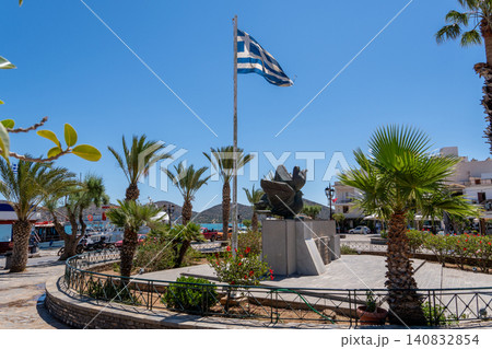 Greek war memorial monument with national flag and palm trees in Elounda town square, Crete, Greece Greek war memorial monument with national flag and palm trees in Elounda town square, Crete, Greece 140832854