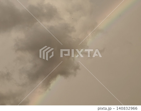 Rainbow Arc Beside Dark Storm Clouds with Bird in Flight 140832966