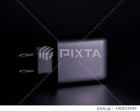 Black battery charger on black background Black battery charger on black background 140833440