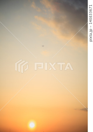沈みゆく美しい夕陽とドラマチックな夕暮れの空を飛ぶ飛行機の風景 沈みゆく美しい夕陽とドラマチックな夕暮れの空を飛ぶ飛行機の風景 140833671