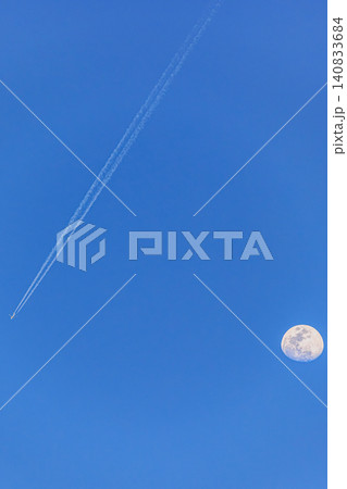 澄み切った晴天の空をまっすぐに進む旅客機と昼の月の美しい共演 澄み切った晴天の空をまっすぐに進む旅客機と昼の月の美しい共演 140833684