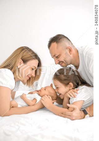 A newborn boy surrounded by his parents and older sister. Love and nurturing in harmony. 140834078