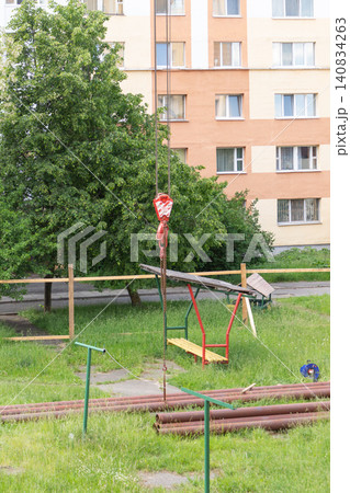 Rusty metal pipes stored on the green grass of a residential playground for utility repair works 140834263