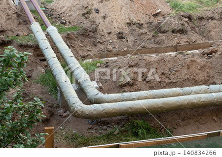 High angle view of insulated utility pipes laid down in a construction site trench for repair works High angle view of insulated utility pipes laid down in a construction site trench for repair works 140834266