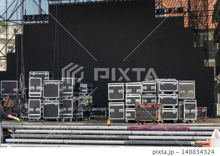 Outdoor concert stage setup with stacked road cases Outdoor concert stage setup with stacked road cases 140834324