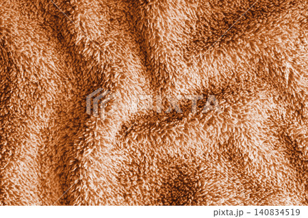 Crumpled fluffy orange terry towel microfiber fabric texture with wrinkles and waves background 140834519