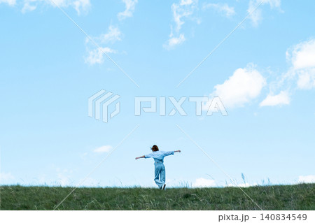 Woman Walking in a Green Field on Rolling Hills, Embracing Freedom and Nature Woman Walking in a Green Field on Rolling Hills, Embracing Freedom and Nature 140834549