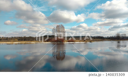 Scenic landscape with a calm river and reflections of trees and clouds. Scenic landscape with a calm river and reflections of trees and clouds. 140835309