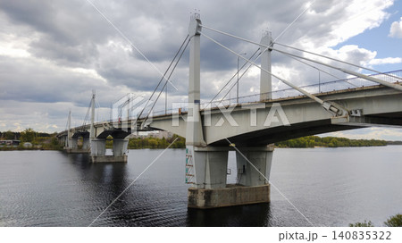 Industrial cityscape with a large concrete bridge reflecting in calm river water. 140835322