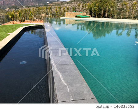 Infinity swimming pool with black water feature in oropesa del mar Infinity swimming pool with black water feature in oropesa del mar 140835552