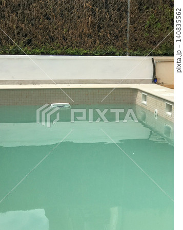 Swimming pool with turquoise water and skimmer Swimming pool with turquoise water and skimmer 140835562